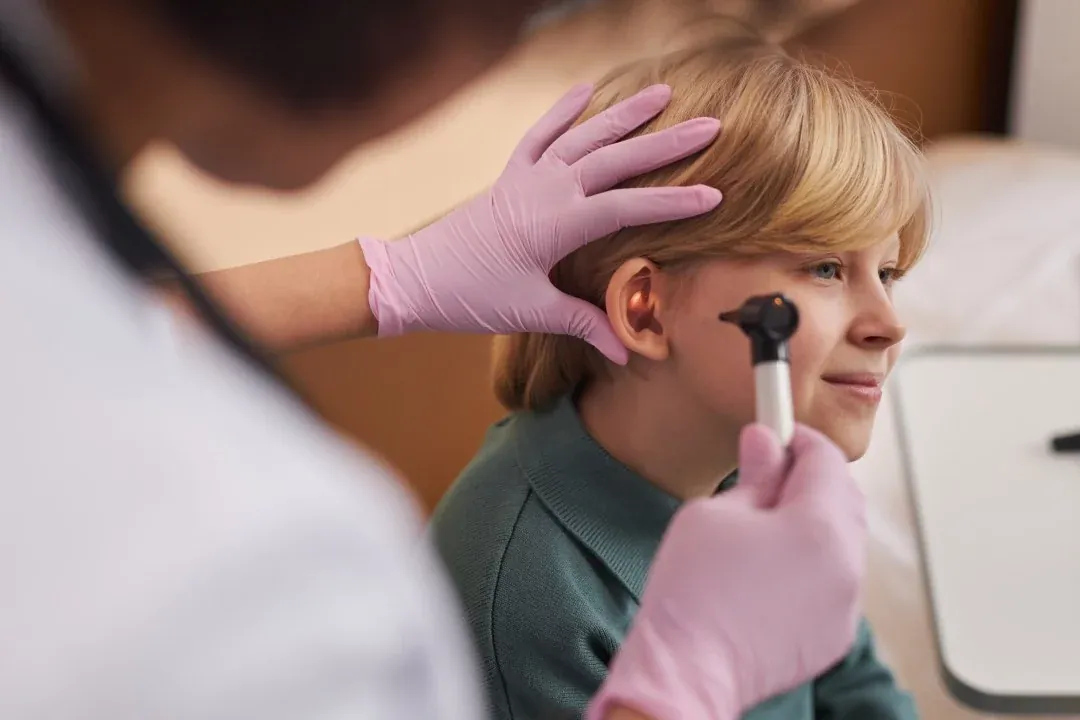 A doctor examining a child&rsquo;s ears and hearing in the clinic