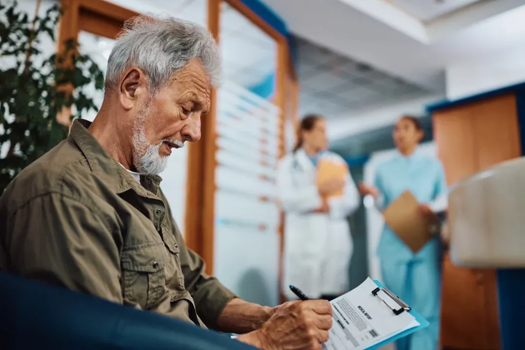 Patient completing a new patient record form at Balwyn Health Care